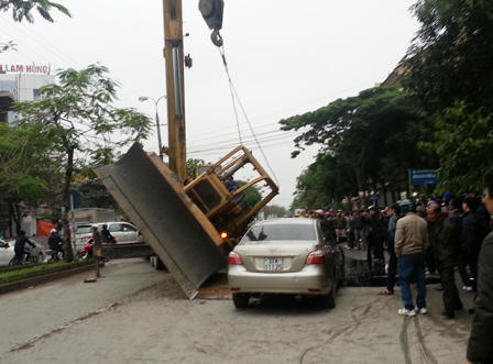 Máy xúc bất ngờ rơi đè bẹp xe con trên đường