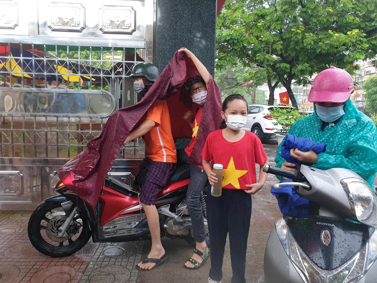 Học sinh đội mưa, đeo kính chắn giọt bắn dự lễ khai giảng