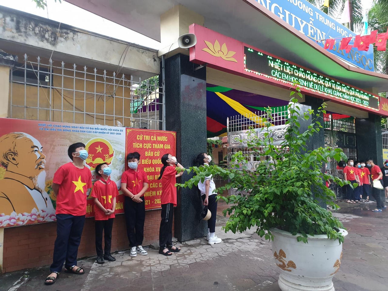 Học sinh đội mưa, đeo kính chắn giọt bắn dự lễ khai giảng