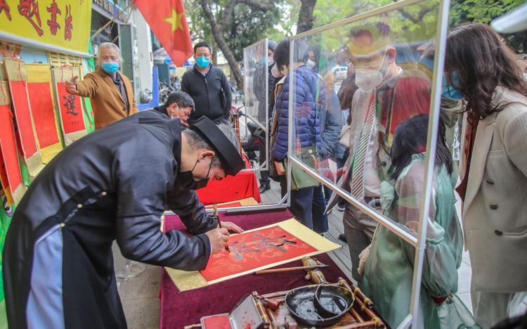 Sĩ tử xếp hàng 'vái vọng', xin chữ đầu năm bên ngoài Văn Miếu ảnh 11