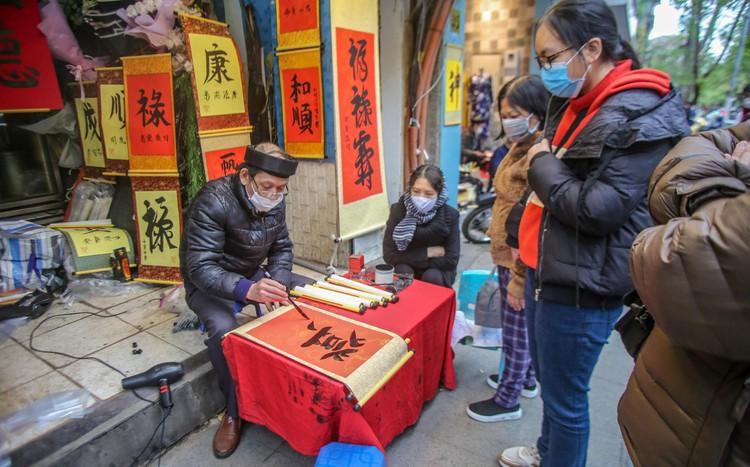 Sĩ tử xếp hàng 'vái vọng', xin chữ đầu năm bên ngoài Văn Miếu ảnh 6