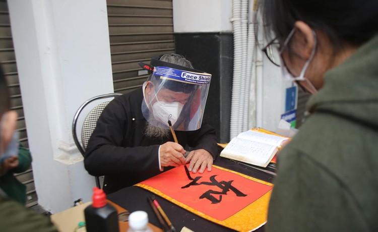 Sĩ tử xếp hàng 'vái vọng', xin chữ đầu năm bên ngoài Văn Miếu ảnh 7