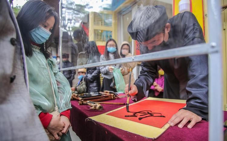 Sĩ tử xếp hàng 'vái vọng', xin chữ đầu năm bên ngoài Văn Miếu ảnh 8