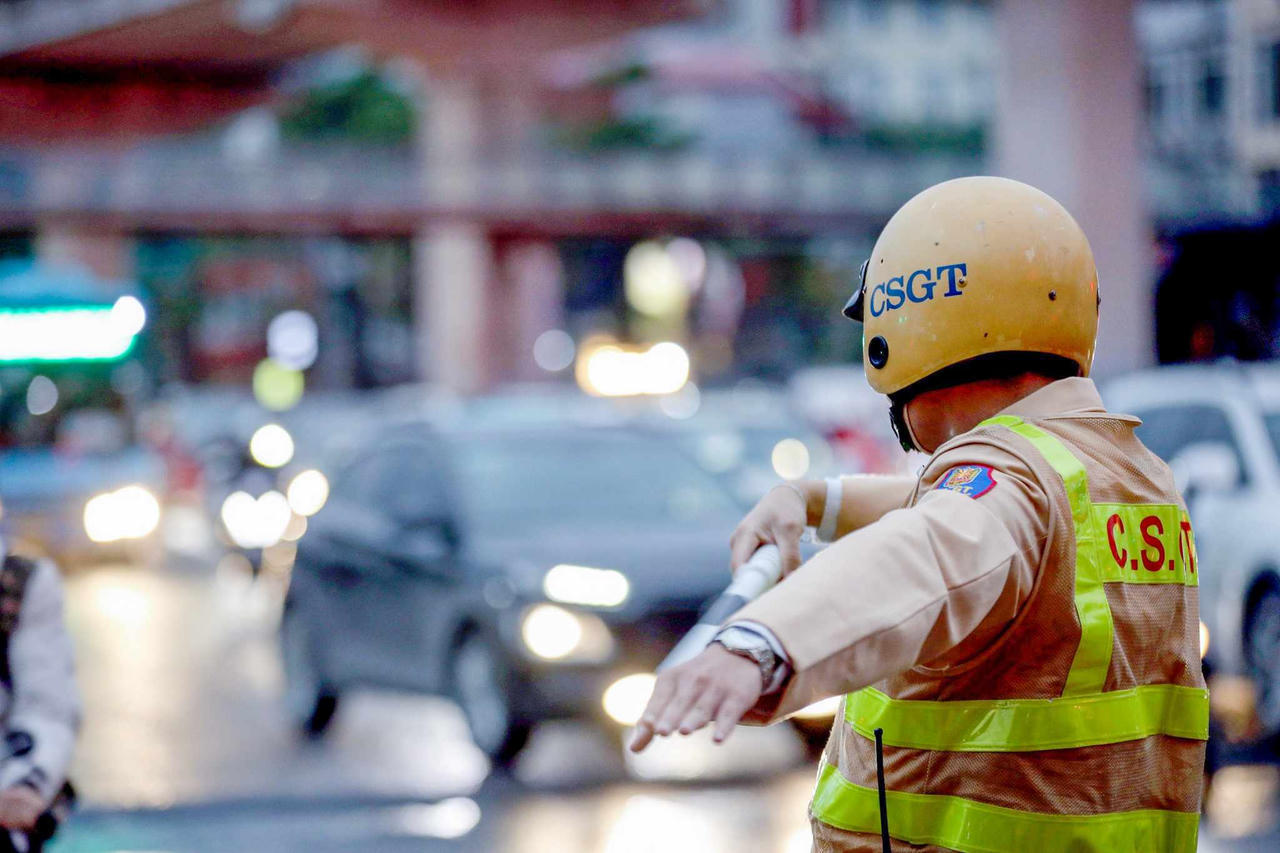 Công an Hà Nội 'căng mình' dưới mưa phân luồng chống ùn tắc