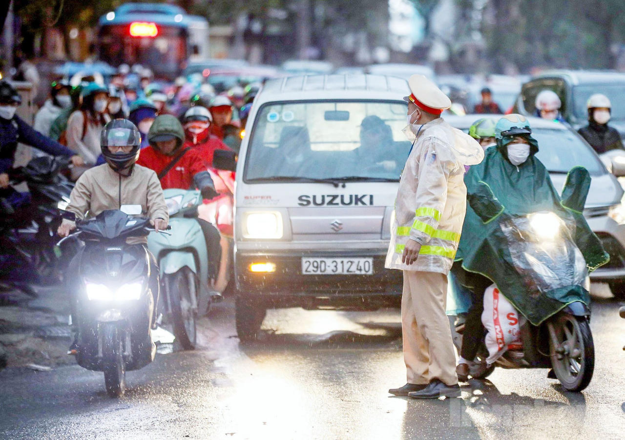 Công an Hà Nội 'căng mình' dưới mưa phân luồng chống ùn tắc