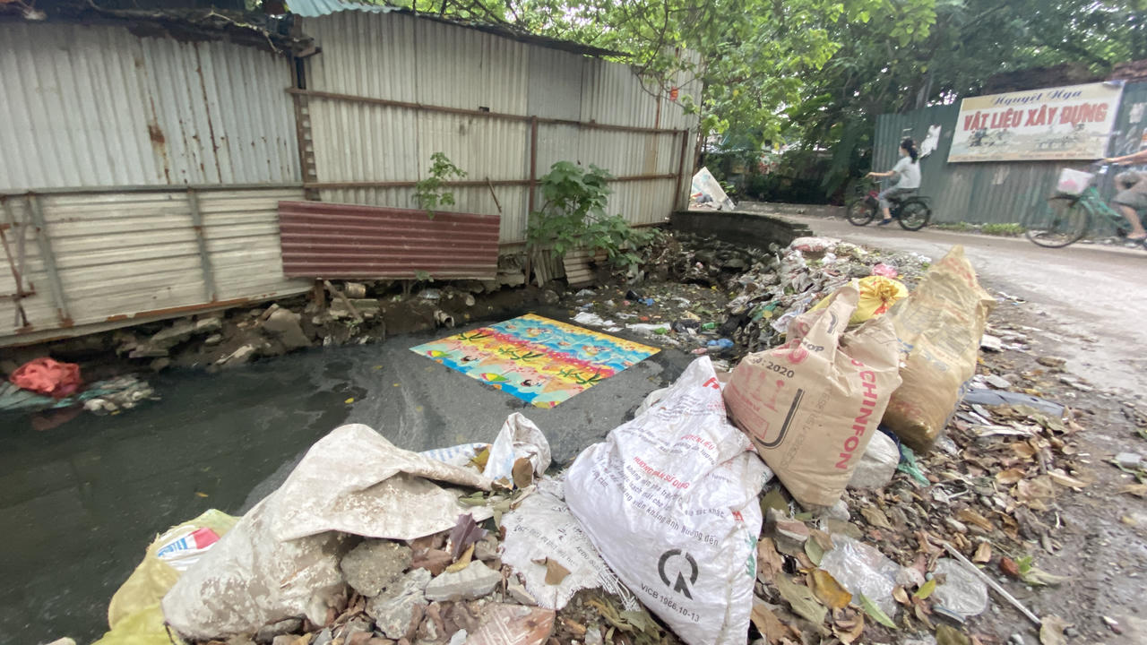 Con mương 'đặc' rác thải gần tuyến đường 'gập ghềnh' ở quận Cầu Giấy (Hà Nội)