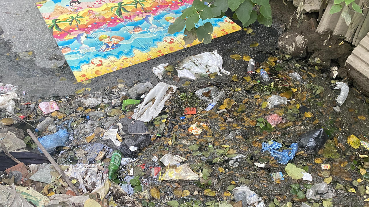 Con mương 'đặc' rác thải gần tuyến đường 'gập ghềnh' ở quận Cầu Giấy (Hà Nội)