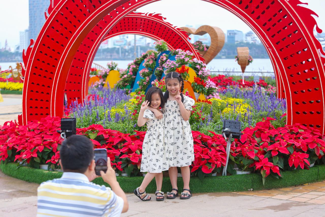 Người dân, du khách xúng xính váy áo 'check-in' đường hoa Tết Đà Nẵng