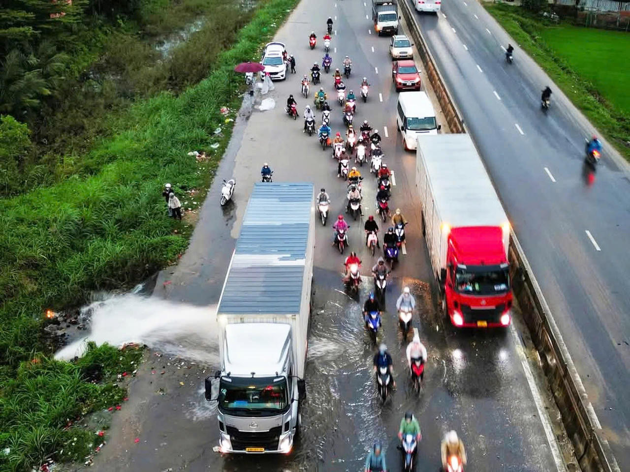 Tài xế xe container nhận "mưa lời khen" khi chắn dòng nước cho xe máy qua đường