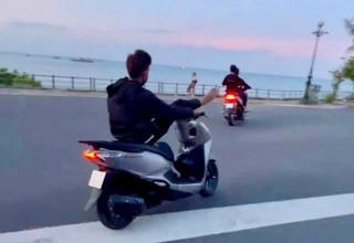 Con gác chân lên đầu xe máy di chuyển trên đường, hai cha con cùng bị phạt