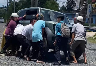 Người dân nâng ô tô cứu bé gái mắc kẹt dưới gầm ô tô
