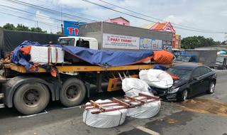 Hàng chục cuộn thép rơi nát đầu xe hơi
