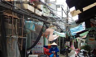 Trụ điện giữa lối đi, dây lòng thòng trên đầu người