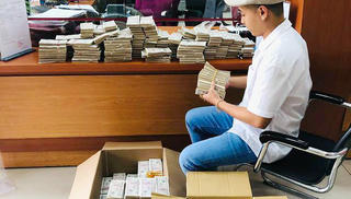 Mang thùng xếp 100.000 tờ tiền lẻ đi gửi tiết kiệm ngân hàng