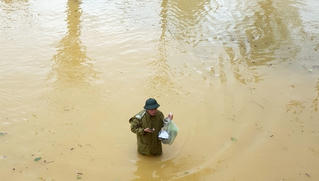 Thầy hiệu trưởng lội nước mang cơm cho sinh viên bị cô lập vì mưa lũ