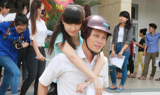 Bố cõng con gái  trên lưng đến phòng thi thực hiện giấc mơ