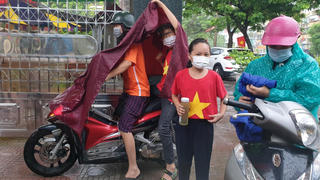 Học sinh đội mưa, đeo kính chắn giọt bắn dự lễ khai giảng