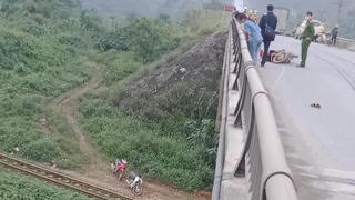 Xe máy tông vào thành cầu, người rơi xuống vực