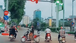 Ngán ngẩm người phụ nữ dừng xe máy giữa ngã tư bấm điện thoại