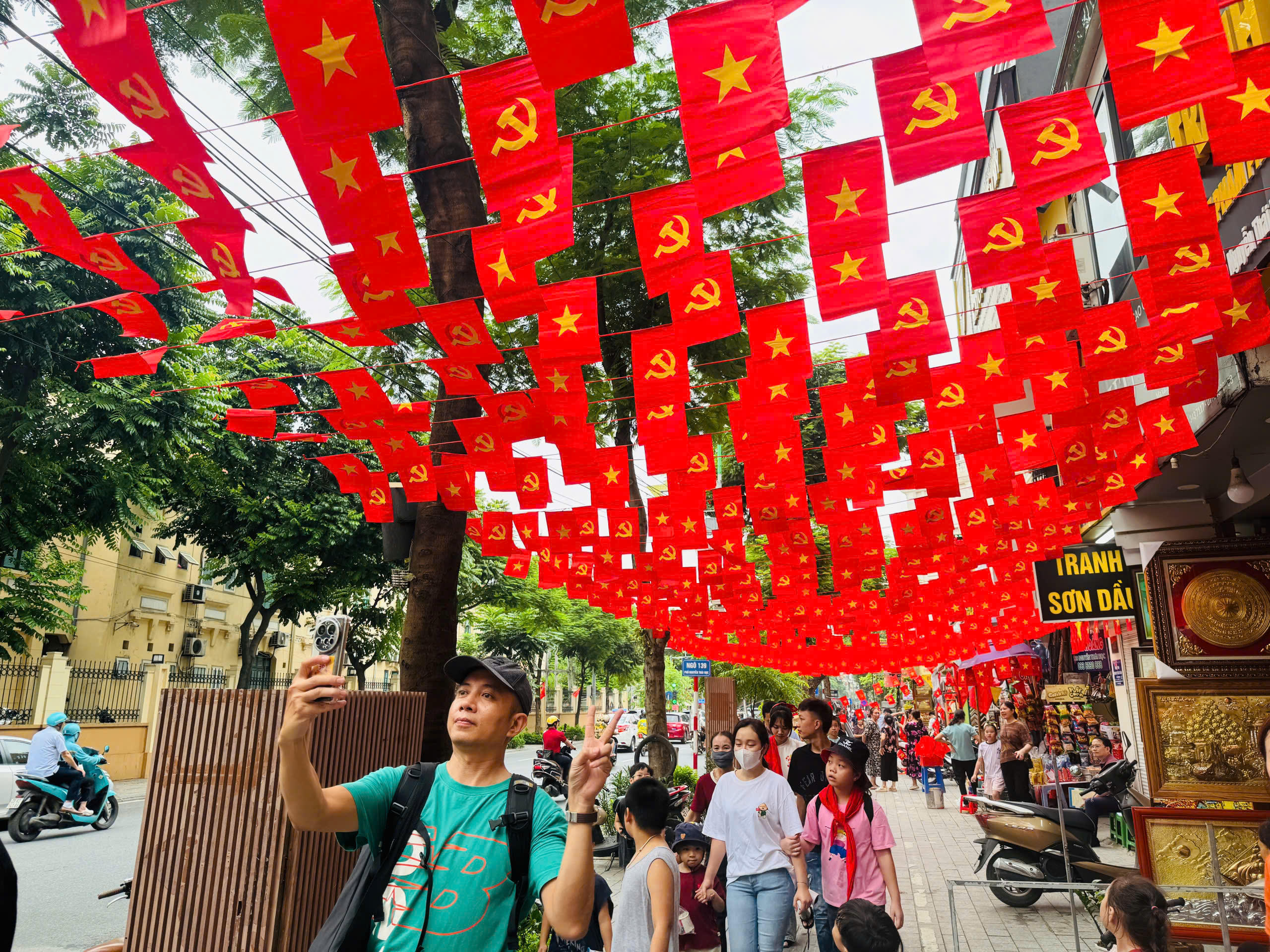 Người dân phấn khởi cùng nhau chụp ảnh kỷ niệm dưới con phố rợp sắc cờ đỏ.