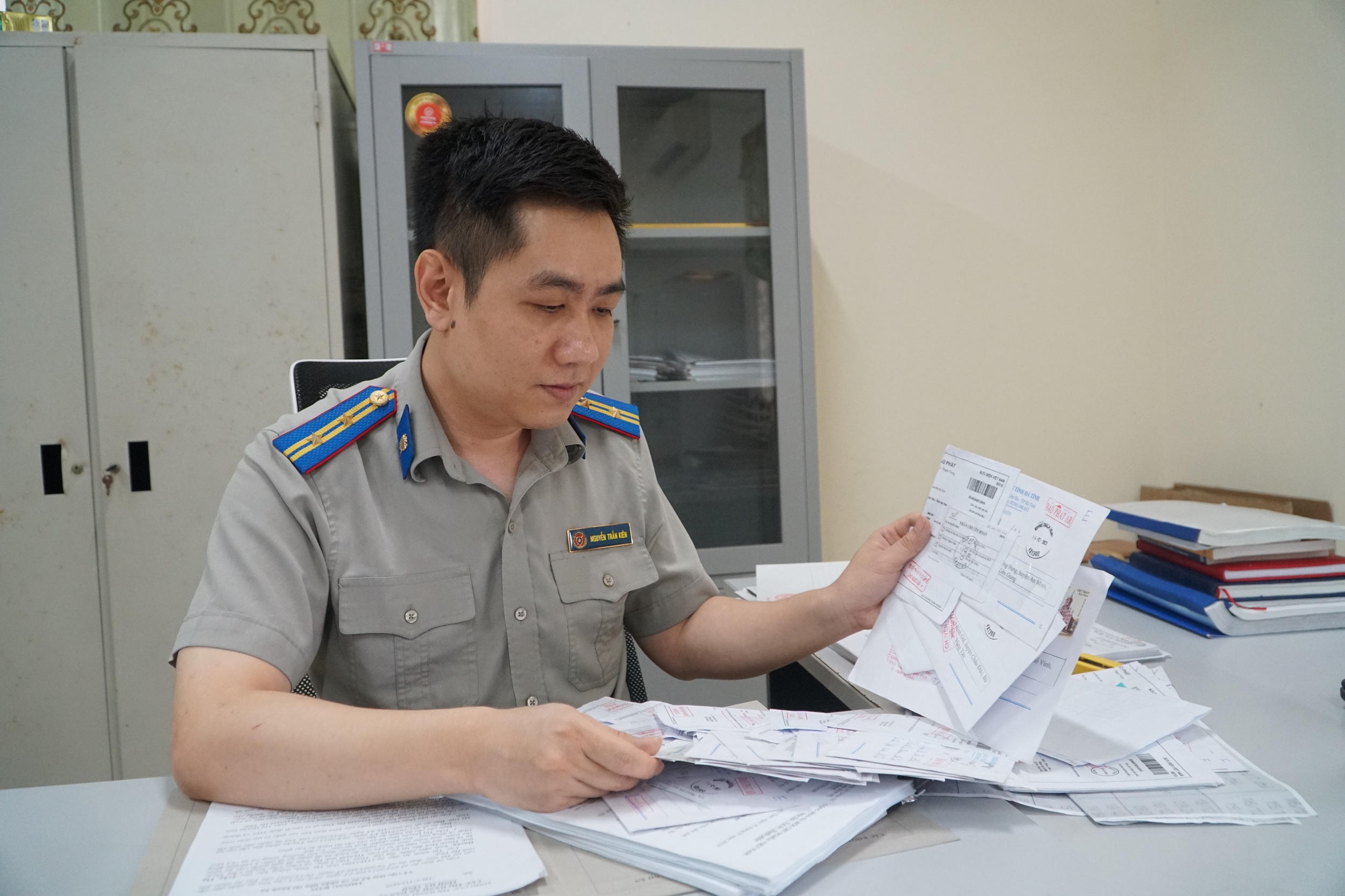 Chấp hành viên Nguyễn Trần Kiên xem lại những thông báo bị trả về. Ảnh: Tuyết Lan