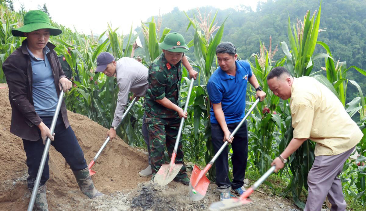Họ gùi cát, sỏi, xi măng để đổ bê tông làm đường. (Ảnh: Hoàng Chính).