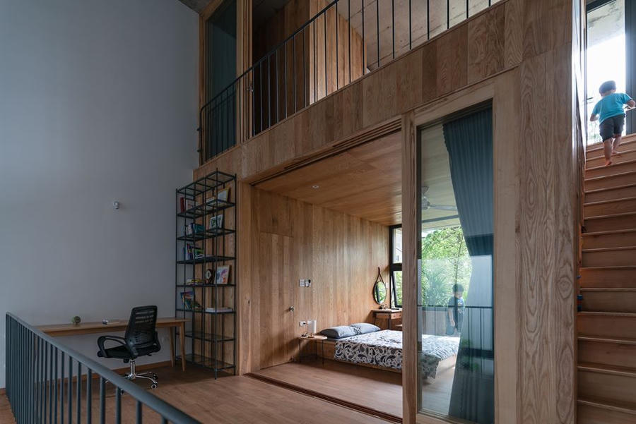 Khu vực phòng ngủ được bố trí trên gác xép với cánh cửa trượt ngăn cách để mọi người có thể thoải mái thư giãn, tận hưởng sự riêng tư. Nội thất trong căn nhà được thiết kế và bài trí đơn giản nổi bật với tông màu gỗ trầm ấm.