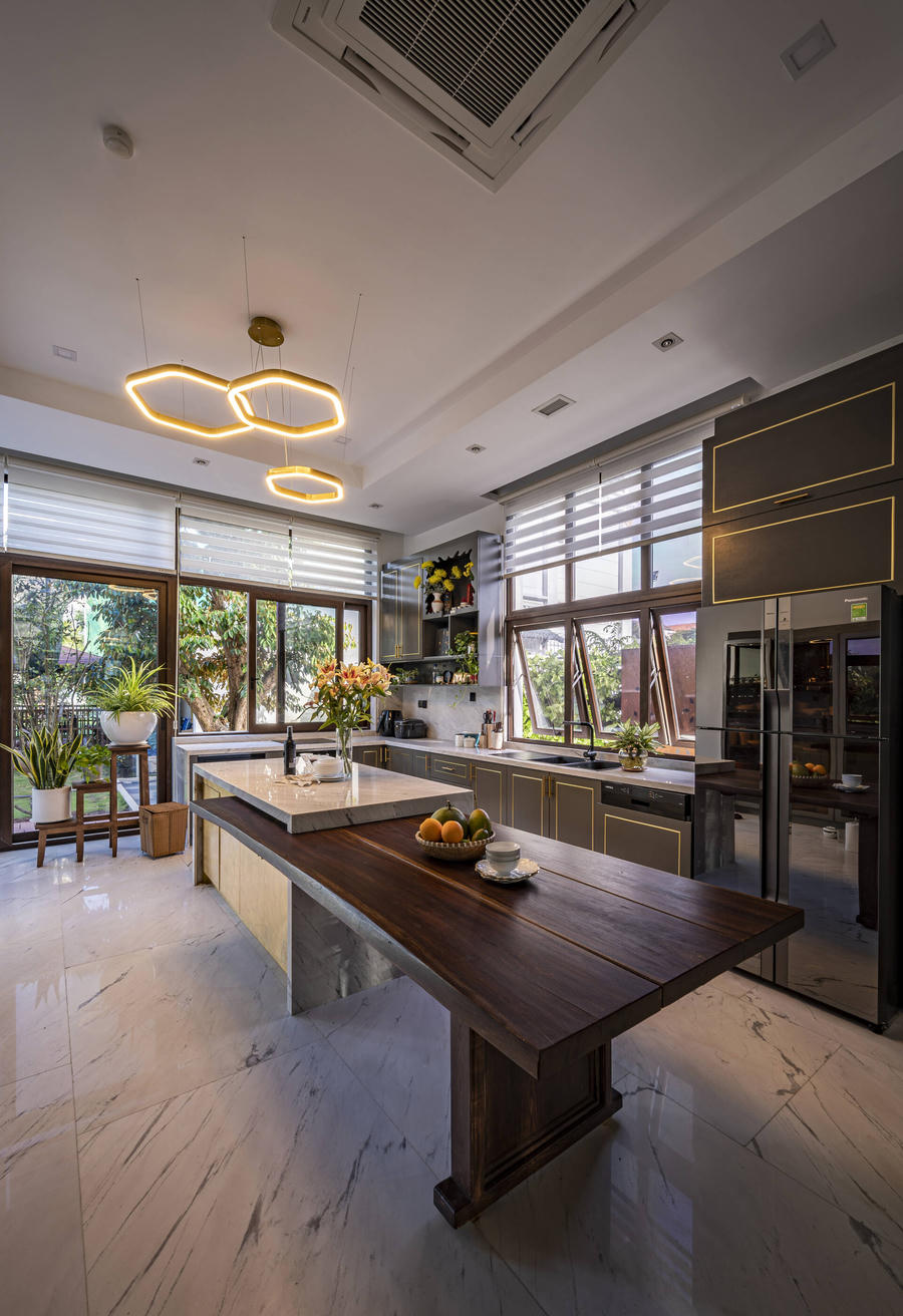 Không gian bếp sử dụng nhiều cửa kính tạo sự kết nối với không gian bên ngoài. Tông màu trầm đem lại cảm giác ấm cúng nhưng không kém phần hiện đại, sang trọng.  