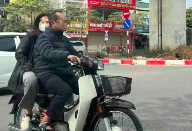 Hình ảnh ông N.P.H. và vợ đi xe máy không đội mũ bảo hiểm bị người dân ghi lại, phản ánh đến cơ quan chức năng qua ứng dụng IHanoi. (Ảnh: Trần Ngọc Quỳnh).