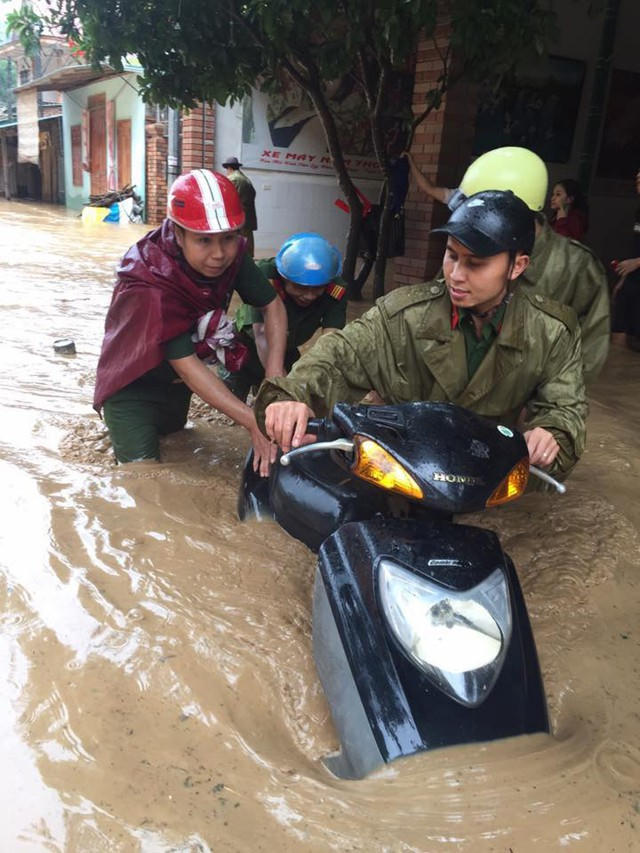 Hàng trăm lượt cán bộ, chiến sĩ dầm mình trong nước lũ giúp người dân sơ tán tài sản, đảm bảo an toàn qua các điểm ngập lụt nặng.