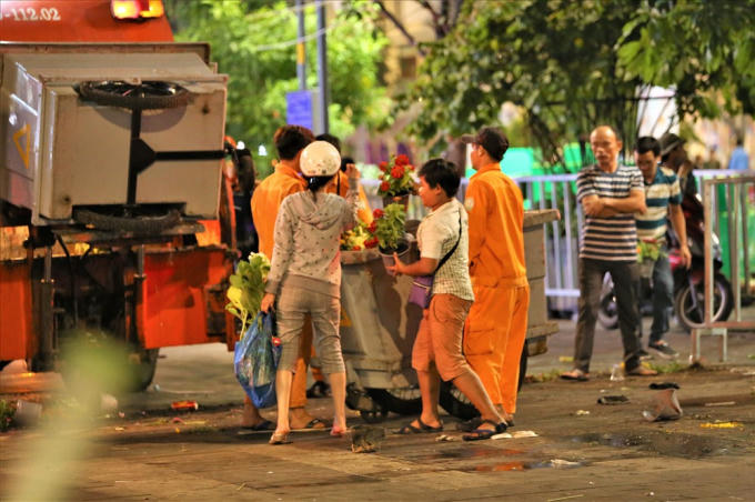 Nhiều người dân cho rằng nếu loại bỏ tất cả những chậu hoa còn đẹp thì sẽ rất phí nên cố gắng vớt vát trước khi chúng bị biến thành rác. Ảnh: Trường Sơn