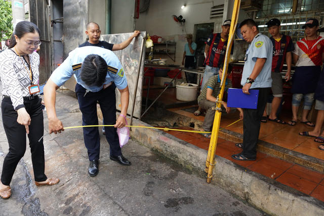 Bà Nga trực tiếp đo để xác định khoảng lấn chiếm vỉa hè của quán nhậu.