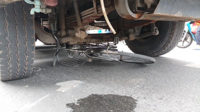 Chiếc xe đạp bị xe ben cuốn vào gầm.