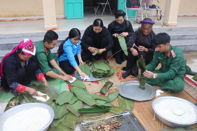 Các cán bộ chiến sĩ cùng bà con chung tay gói những chiếc bánh chưng đầy tình nghĩa quân dân.