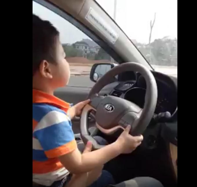 Cậu bé tỏ ra khá thích thú khi được điều khiển ô tô. (Ảnh cắt từ clip)