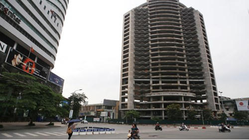 Cao ốc hoang nằm trơ xương đắp chiếu trên đất vàng. Trong ảnh là tòa cao ốc Lucky Tower I (Thái Hà, Hà Nội) đã dừng thi công nhiều năm khiến bộ mặt đô thị thêm nhếch nhác. (Ảnh: Tiền phong).