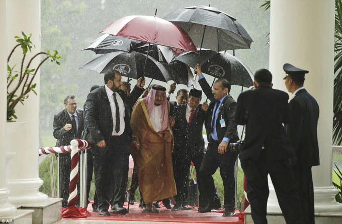 Vua Saudi và Tổng thống Indonesia Joko Widodo được 7 tùy tùng đi theo để che mưa.