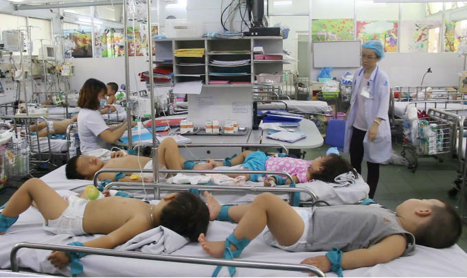 12 y bác sĩ ở khoa này hiện đang chăm sóc, điều trị cho 179 bệnh nhi. Do bệnh nhi nhập viện quá đông, 2 bé phải nằm 1 giường bệnh. Bệnh nhi nằm thiêm thiếp, tay chân được buộc chặt vào thành giường tránh co giật.
