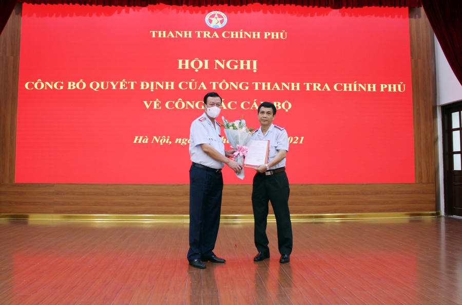 Tổng Thanh tra Chính phủ Đoàn Hồng Phong trao quyết định và tặng hoa chúc mừng tân Phó Vụ trưởng Vụ I Đinh Đăng Lập. Ảnh: PH