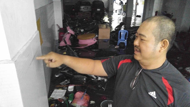 Anh Sơn, chủ đại lý gạo chỉ tay vào vệt nước trên tường tầng hầm và cho biết: Mưa quá lớn khiến tầng hầm của PV Bank biến thành bể bơi.