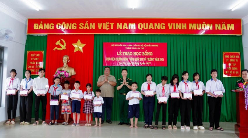 Đại tá Phạm Lê Xuân Bình và ông Lâm Sao trao học bổng cho các em học sinh. Ảnh: Văn Long
