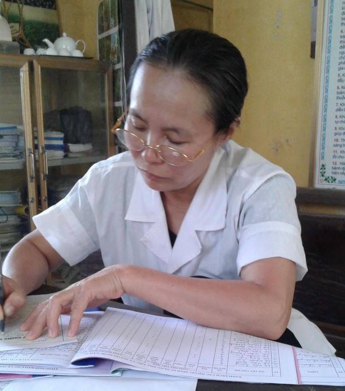 Trạm trưởng x&atilde; Hoằng Ph&uacute; đang viết giấy chứng nhận sức khỏe cho người lao động.