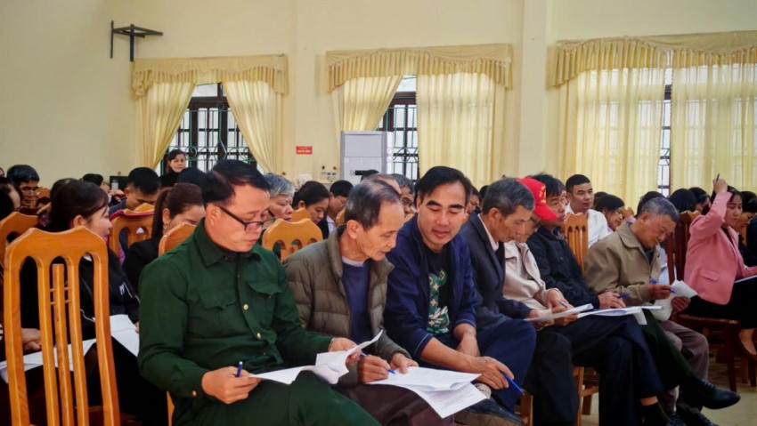 Người dân tại Hội nghị chăm chú nghiên cứu tài liệu liên quan đến việc trợ giúp pháp lý tại địa phương.