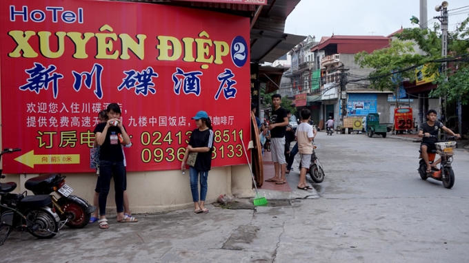 Biển hiệu quảng cáo một khách sạn gồm 3 ngôn ngữ, trong đó chỉ tên khách sạn viết bằng chữ Việt Nam.