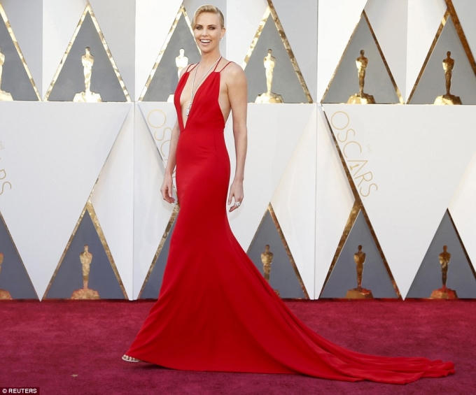 Charlize Theron hấp dẫn sải bước với chiếc đầm màu đỏ cắt xẻ sâu ở ngực khoe hững hờ vòng 1.