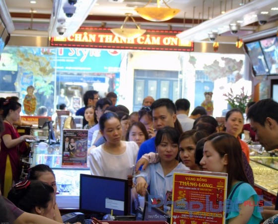 Nhiều người dân xếp hàng đi tại các điểm giao dịch để chờ đến lượt.(Ảnh Hà Đương).