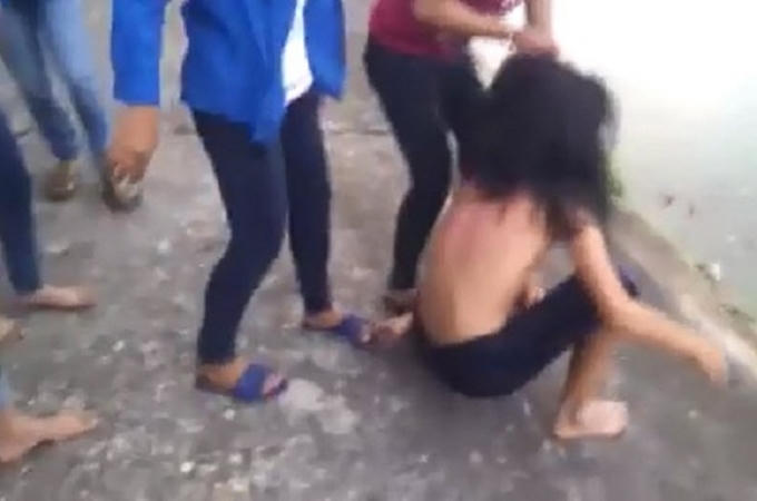 Nhóm người hành hung cố đẩy cô gái xuống hồ.