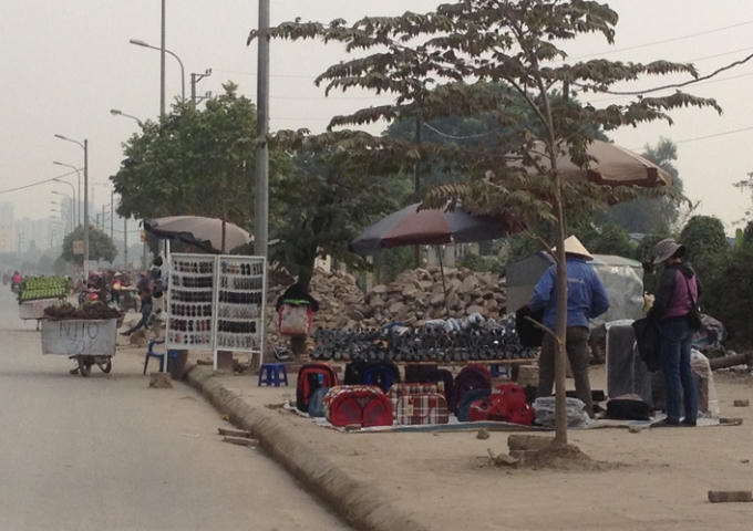 Không chỉ bán ở lề đường, các thương lái còn tràn xuống lấn chiến luôn mặt đường gây mất an toàn cho người tham gia giao thông.