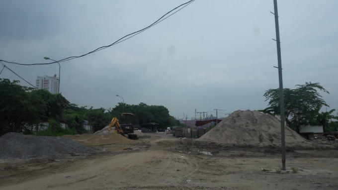 Vật liệu xây dựng, máy xúc tạp kết trên đất nông nghiệp.