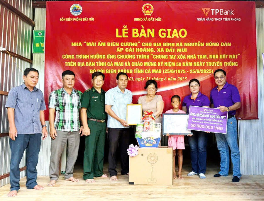 Thiếu tá Phạm Nam Sơn - Chính trị viên Đồn Biên phòng Đất Mũi (BĐBP Cà Mau) và nhà tài trợ tặng quà và bàn giao nhà cho bà Nguyễn Hồng Dân.